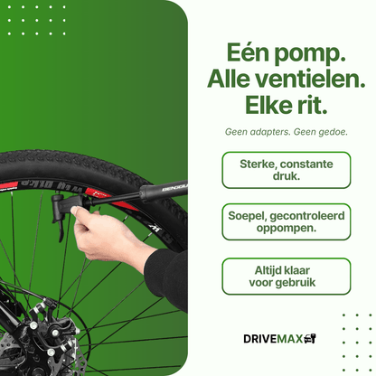 Hand using a black DriveMax bicycle pump on a mountain bike tire against a green background.